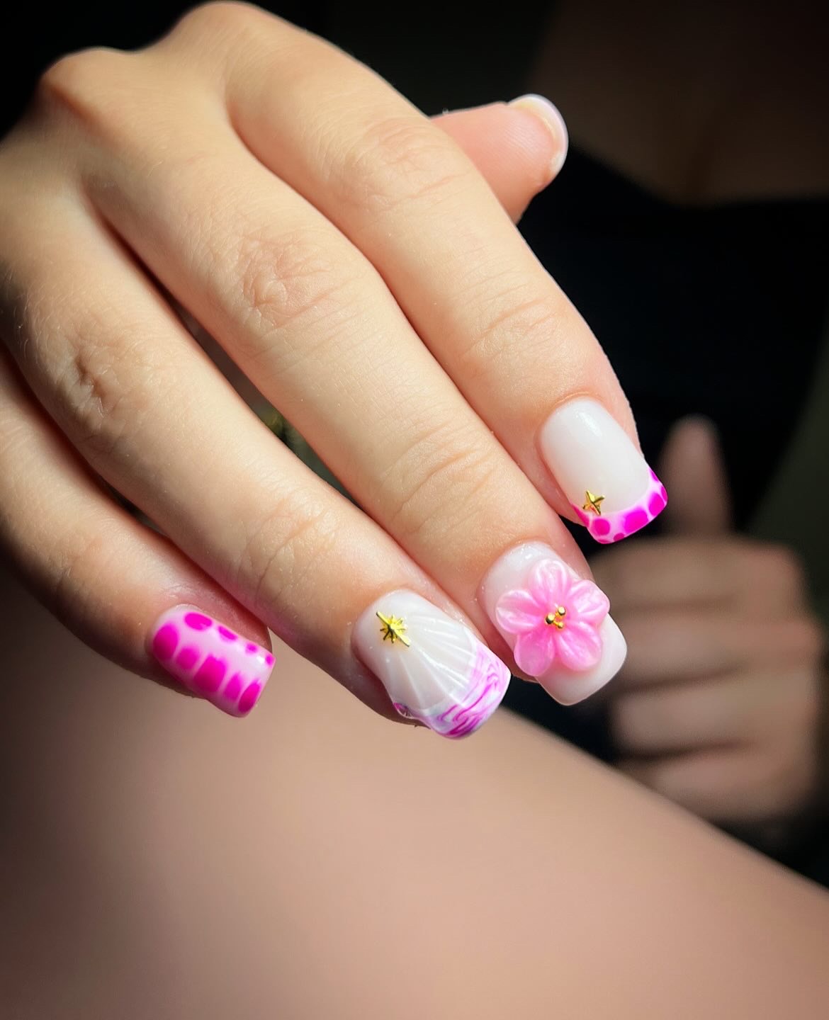 Witte nagels met een roze 3D-bloem en een roze tie-dye nagel