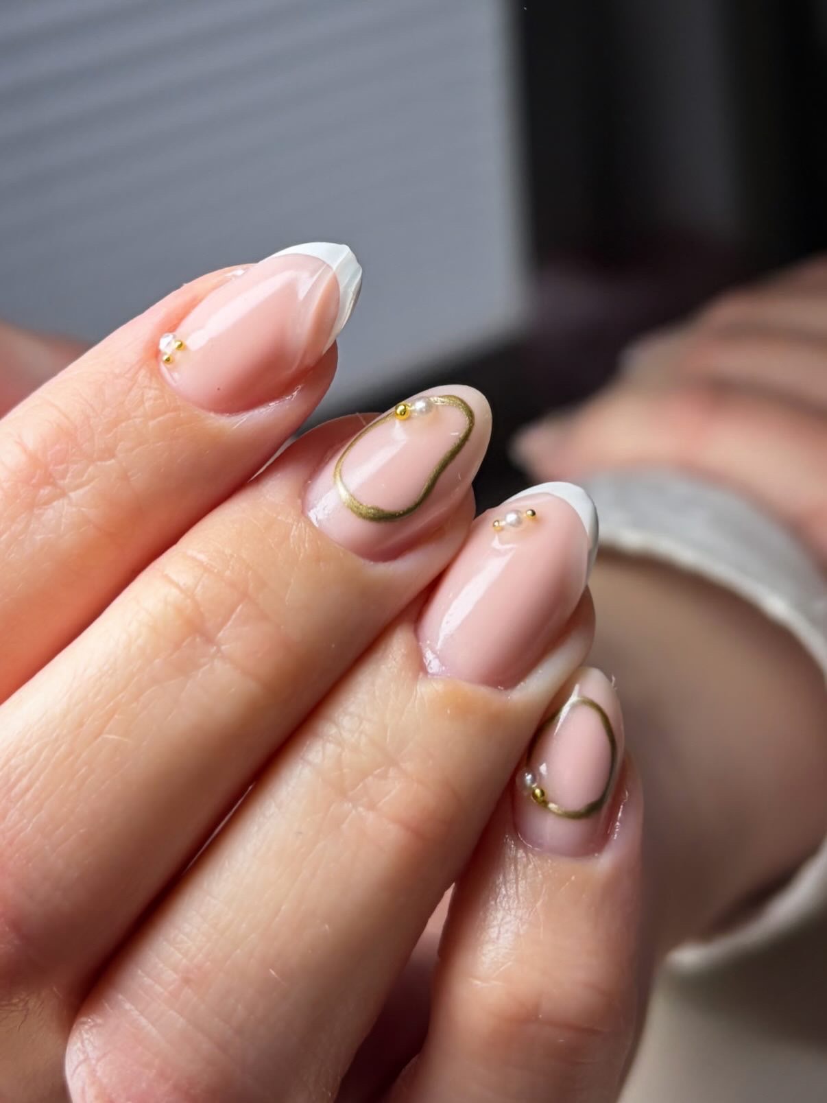 Nude amandelnagels met gouden lijntjes en kleine gouden sterretjes