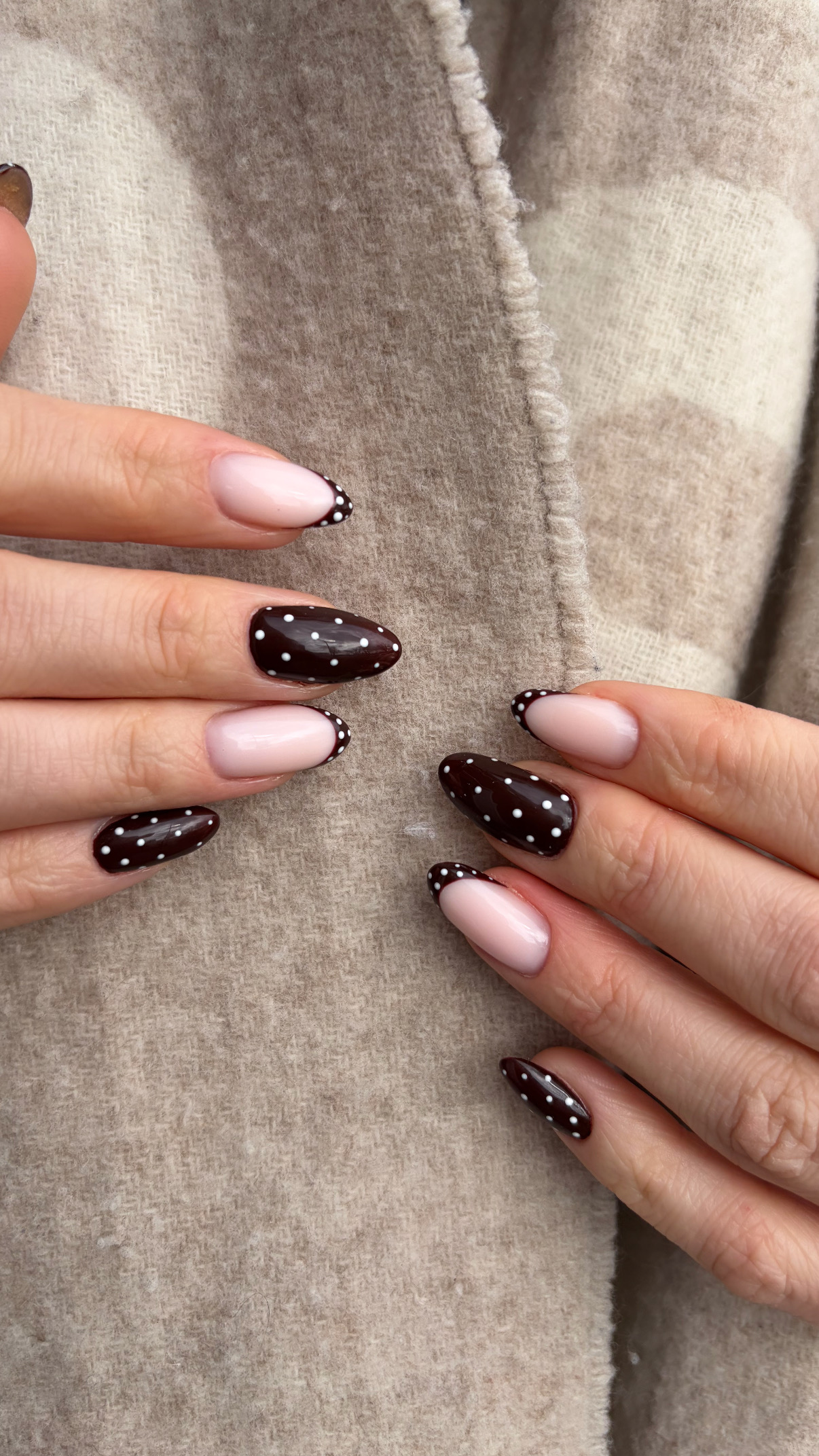 Chocoladebruine nagels met witte stipjes naast lichtroze nagels met een witte tip